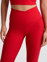 red high-waisted midi legging with criss cross front detail.